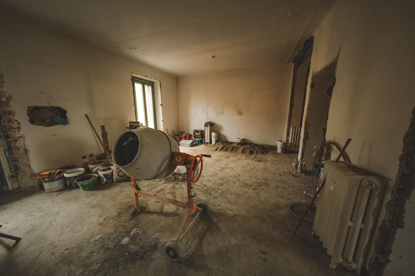 Burkolásra előkészített, kiegyenlített beton aljzat egy felújítás alatt álló helyiségben.